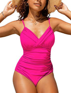 Femme portant un maillot de bain une pièce rose vif, bretelles fines, col en V croisé, posant en extérieur ensoleillé. Mode plage été.