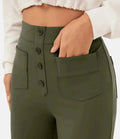 Femme portant un pantalon taille haute vert avec boutons et poches avant, chemise blanche. Mode féminine, style décontracté, tendance actuelle.
