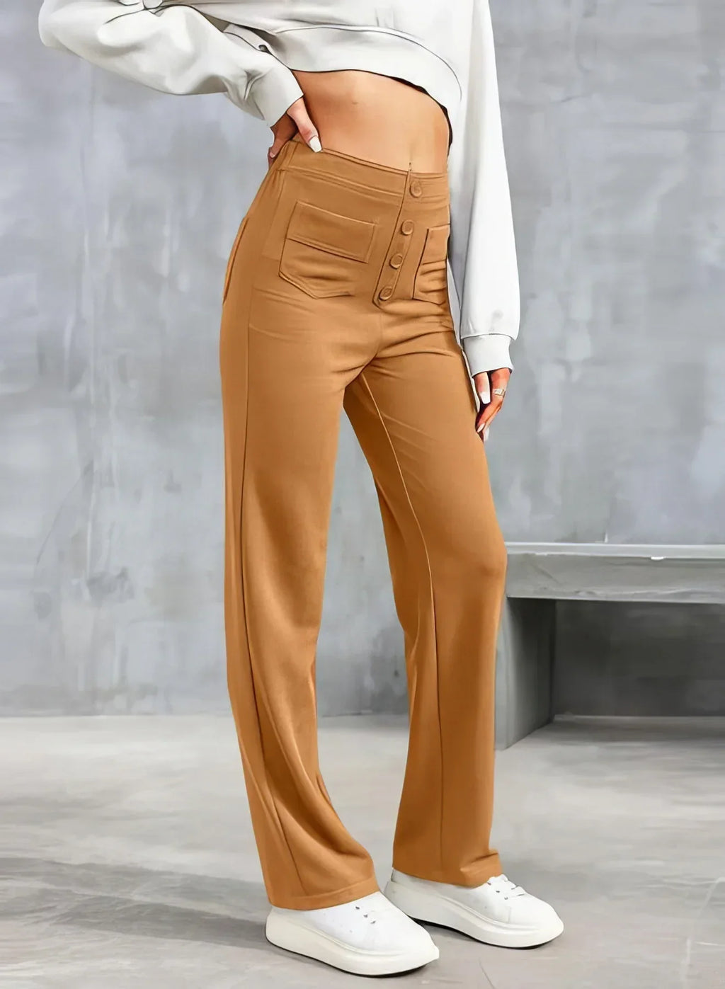 Pantalon taille haute marron pour femme, avec boutons et poches, porté avec un sweat blanc. Mode élégante et décontractée, tendance automne.