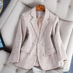 Blazer en tweed beige pour femme, élégant et texturé, posé sur un fauteuil beige. Mode féminine, veste chic, tendance automne-hiver.