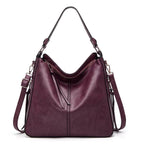 Sac à main en cuir bordeaux pour femme avec bandoulière réglable, design élégant et moderne, idéal pour la mode et le quotidien.