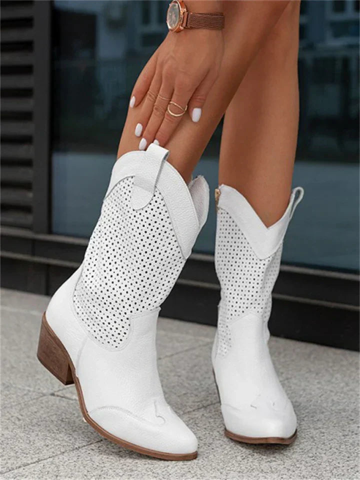 Bottes blanches en cuir perforé pour femme, talon moyen, style western, portées avec élégance. Mode tendance, chaussures d'été.