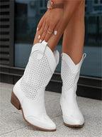 Bottes blanches en cuir perforé pour femme, talon moyen, style western, portées avec élégance. Mode tendance, chaussures d'été.