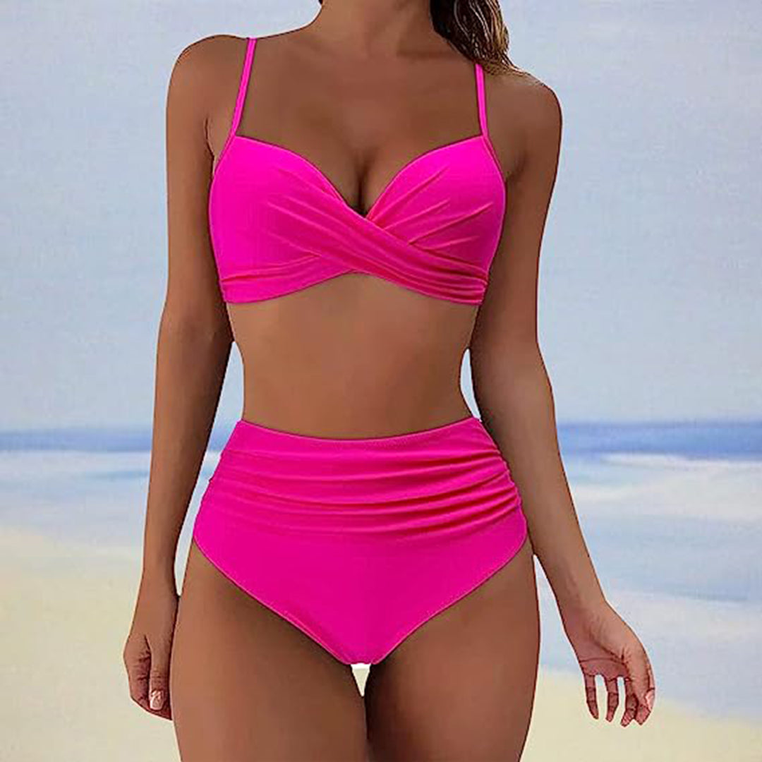 Femme en bikini rose vif sur fond de plage, maillot de bain deux pièces, style croisé, tendance été, mode balnéaire, ciel bleu, mer.