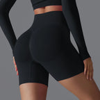 Femme portant un short de sport noir taille haute, mettant en valeur la silhouette. Vêtements de fitness, mode active, confort et style.