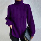 Pull-over violet à col roulé en maille épaisse, porté avec un sac à main noir matelassé à chaîne dorée. Mode automne-hiver élégante.