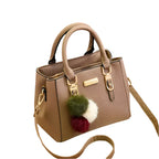 Sac à main en cuir beige avec bandoulière, ornements pompons colorés, détails dorés. Accessoire mode élégant pour femme, tendance et chic.