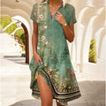 Robe d'été verte à motifs floraux, manches courtes, col en V, portée par une femme dans un couloir lumineux. Mode féminine, style décontracté.