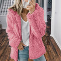 Femme portant un manteau en fausse fourrure rose, tenue décontractée avec jean et t-shirt blanc, mode automne-hiver, intérieur maison.