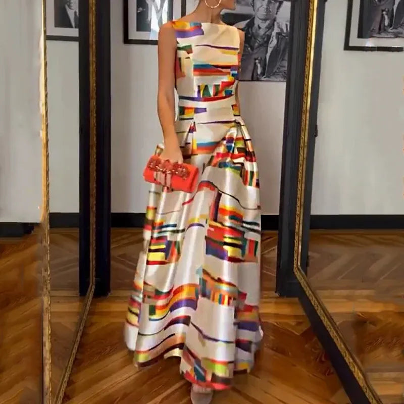 Robe longue colorée à motifs géométriques, portée par une femme tenant une pochette rouge, dans une pièce avec parquet et miroirs.