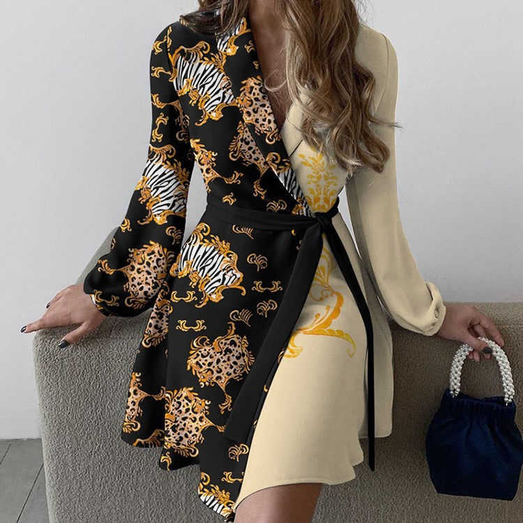 Robe asymétrique élégante avec motifs animaliers, manches longues, ceinture noire, tenue chic pour femme, sac à main bleu, style moderne et tendance.