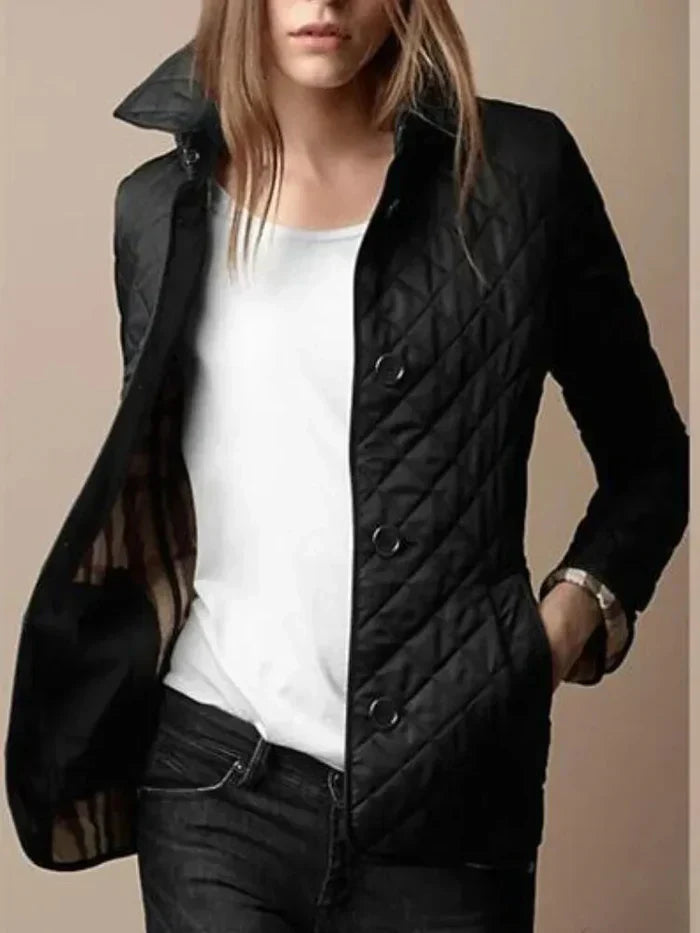 Femme portant une veste matelassée noire élégante, col relevé, sur un t-shirt blanc, style décontracté chic, mode automne-hiver tendance.