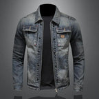 Veste en jean bleu pour homme sur fond gris, style décontracté, avec poches poitrine et fermeture éclair. Mode masculine tendance.