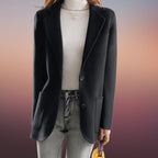 Veste blazer noir femme élégante, manches longues, portée sur un pull blanc, avec jean décontracté. Mode automne-hiver, style chic et moderne.