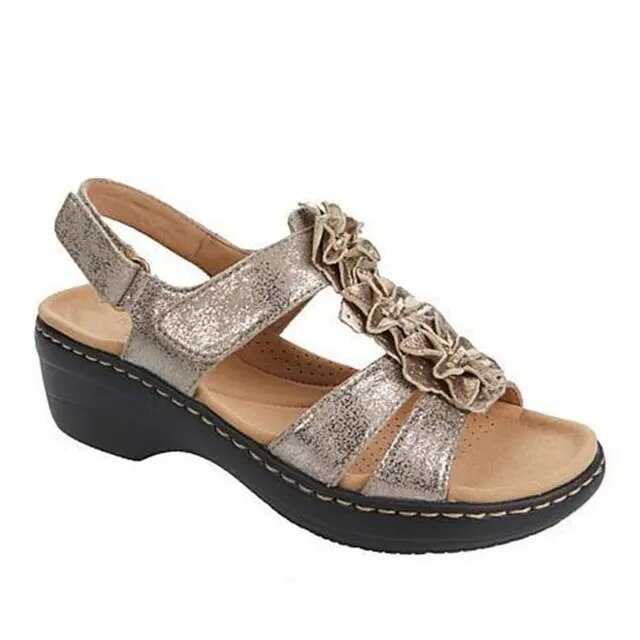 Sandale compensée dorée pour femme avec brides décoratives et semelle noire. Chaussure élégante et confortable, idéale pour l'été.