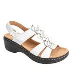 Sandale blanche pour femme avec talon compensé noir, bride arrière et détails floraux. Chaussure d'été élégante et confortable.