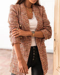Femme portant une veste en tweed multicolore, débardeur blanc, collier doré et pantalon noir. Mode élégante, tendance automne, style chic.