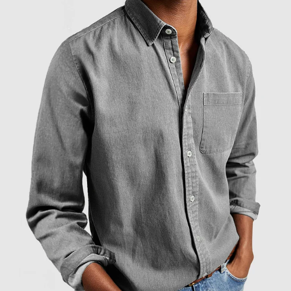 Chemise en jean gris pour homme, manches longues, poche poitrine, style décontracté, mode masculine, tenue élégante, fond gris clair.