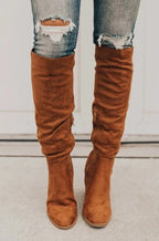 Bottes hautes en daim marron, style décontracté, portées avec un jean déchiré. Mode automne, tendance chaussures femme.