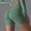 Femme en tenue de sport verte, leggings taille haute, accentuant la silhouette. Mode fitness, vêtements de sport confortables et tendance.
