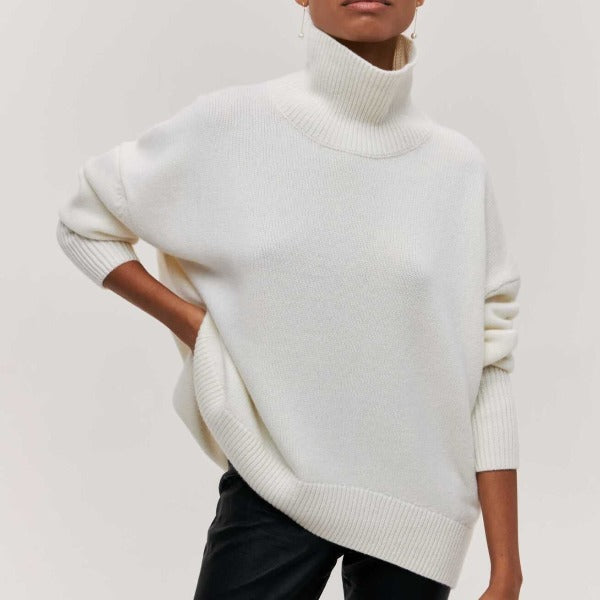 Femme portant un pull blanc à col roulé, manches longues, style décontracté. Mode automne-hiver, tendance vêtements chauds, élégance minimaliste.