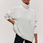 Femme portant un pull blanc à col roulé, manches longues, style décontracté. Mode automne-hiver, tendance vêtements chauds, élégance minimaliste.