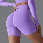 Femme en tenue de sport violette, leggings taille haute, pose de profil. Mode fitness, vêtements de sport tendance, style athlétique.