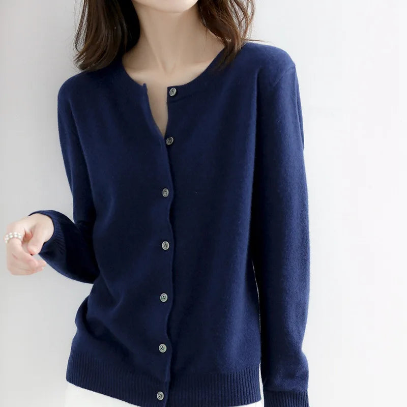 Femme portant un cardigan bleu marine en laine, boutonné, manches longues, style élégant et décontracté, mode automne-hiver.