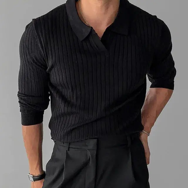Homme portant un pull noir côtelé à manches longues et un pantalon noir élégant, style mode masculine chic et moderne.