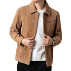 Homme portant une veste en velours côtelé marron, chemise blanche et pantalon noir. Mode masculine élégante, tenue automne-hiver tendance.