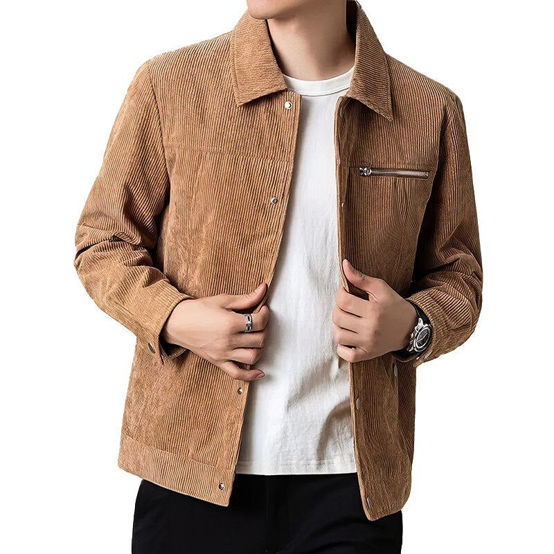 Homme portant une veste en velours côtelé marron, chemise blanche et pantalon noir. Mode masculine élégante, tenue automne-hiver tendance.
