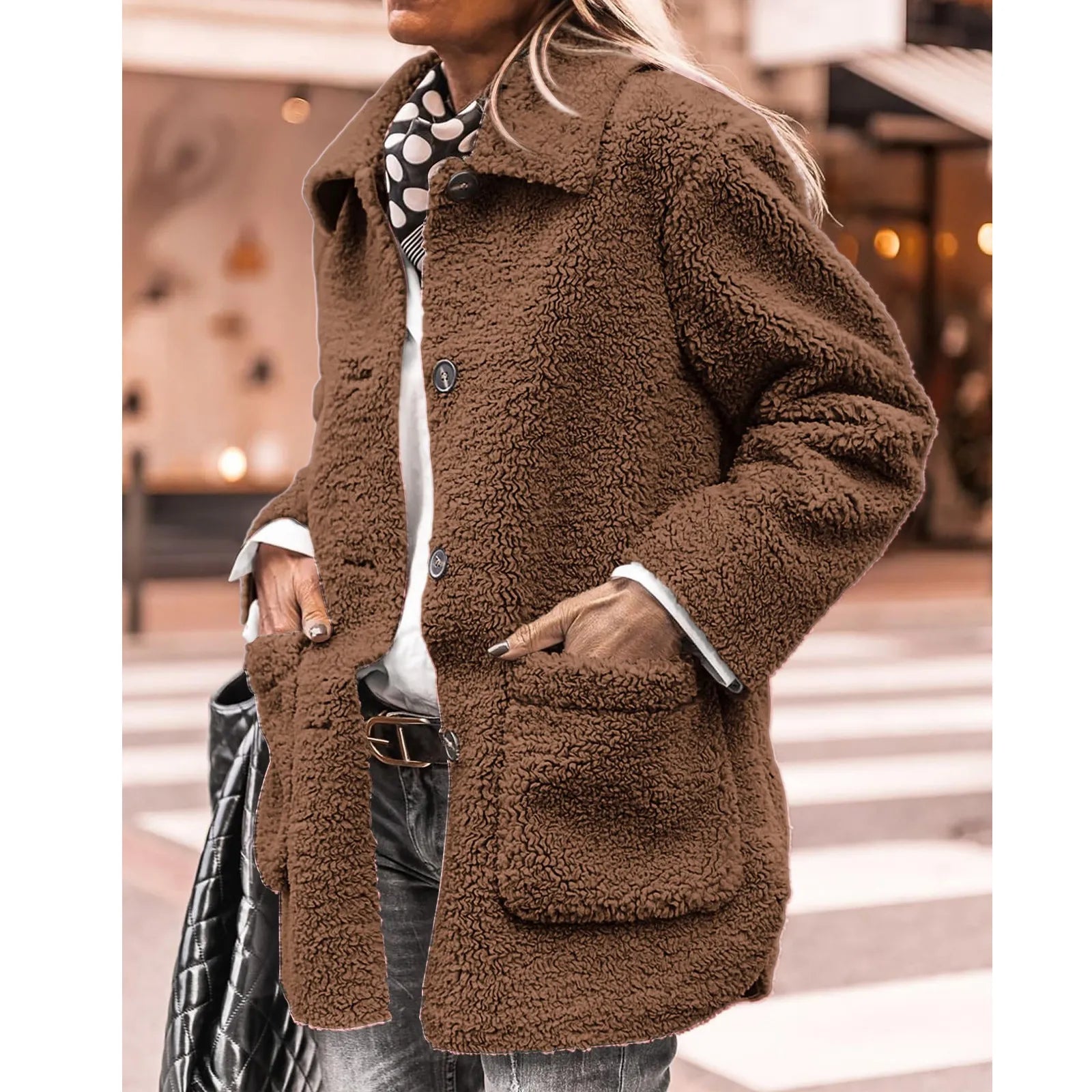 Femme portant un manteau en fausse fourrure marron, style décontracté, avec écharpe à pois, sur fond urbain. Mode automne-hiver tendance.