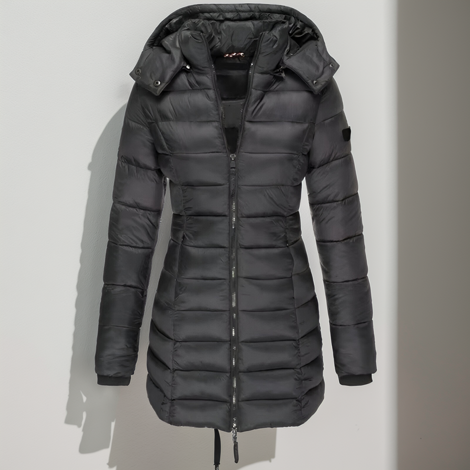 Doudoune noire longue avec capuche amovible, fermeture éclair frontale, design matelassé, idéale pour l'hiver et les températures froides.