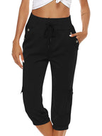 Femme portant un pantalon cargo noir taille haute avec cordon, poches latérales et ourlets élastiques, style décontracté et moderne.