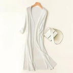 Robe longue blanche élégante sur cintre, accompagnée d'un sac à main blanc minimaliste. Mode féminine chic, style épuré et moderne.