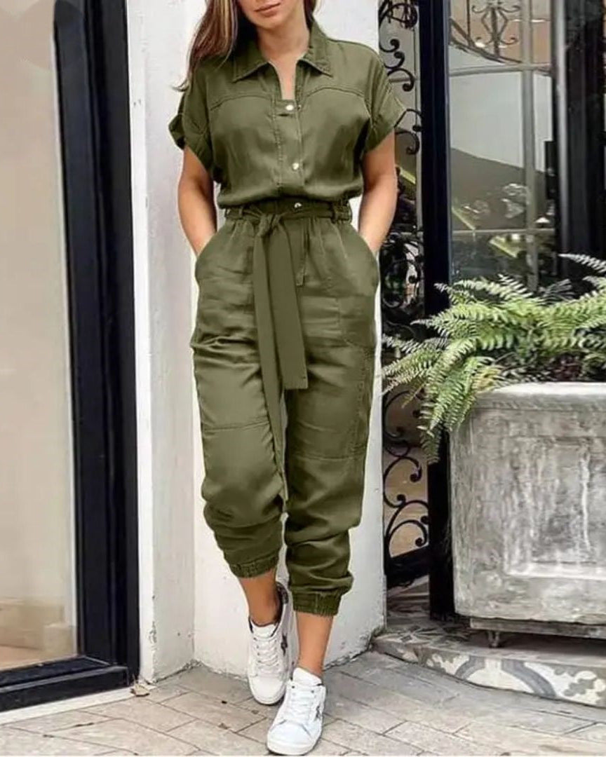 Combinaison kaki femme élégante, manches courtes, ceinture nouée, poches, portée avec baskets blanches. Mode décontractée chic, tendance urbaine.