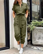 Combinaison kaki femme élégante, manches courtes, ceinture nouée, poches, portée avec baskets blanches. Mode décontractée chic, tendance urbaine.
