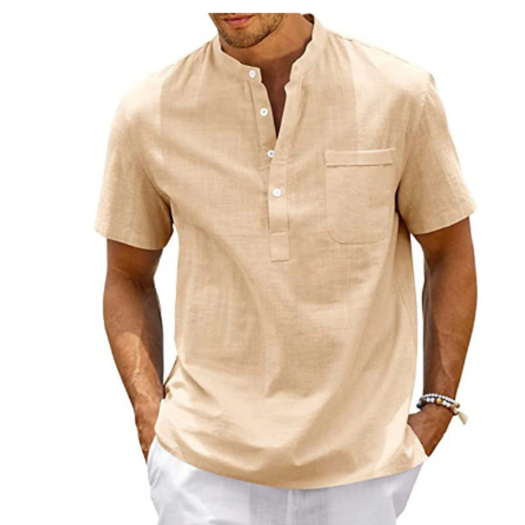 Homme portant une chemise beige à col mao, manches courtes, avec poche poitrine, style décontracté. Mode masculine estivale élégante.