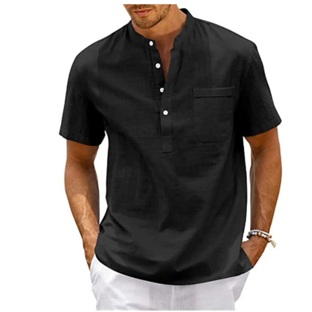 Homme portant une chemise noire à col mao, manches courtes, avec boutons et poche poitrine, style décontracté. Mode masculine élégante.