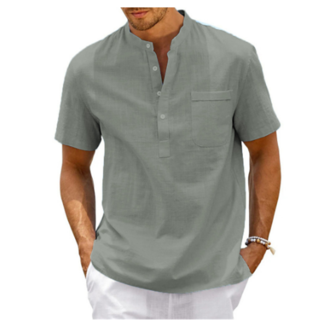 Homme portant une chemise en lin gris à manches courtes avec col mao et poche poitrine, style décontracté estival, mode masculine élégante.