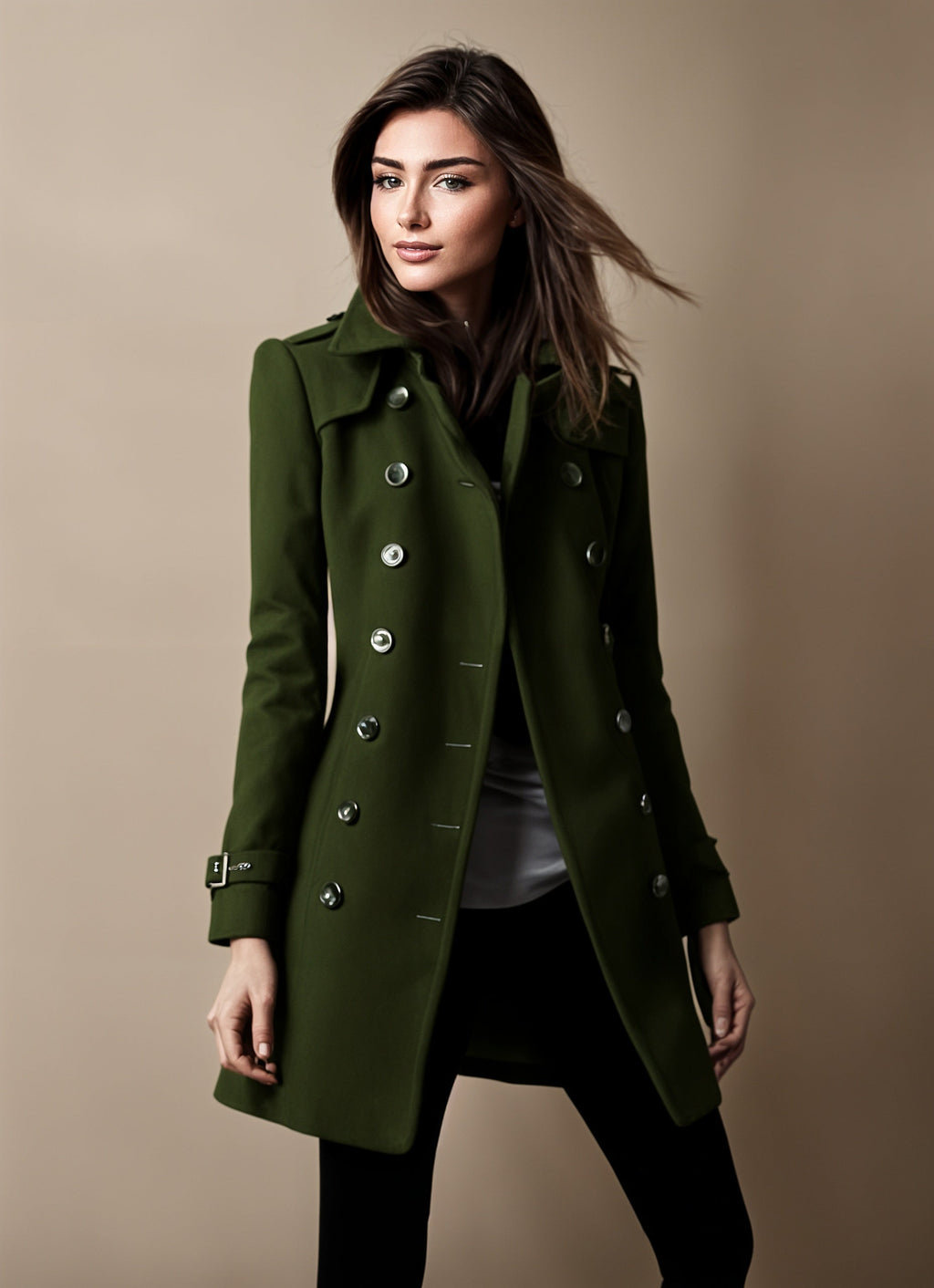 Femme portant un manteau vert élégant à double boutonnage, style automne-hiver, sur fond beige. Mode féminine, tendance, chic.