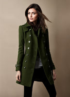 Femme portant un manteau vert élégant à double boutonnage, style automne-hiver, sur fond beige. Mode féminine, tendance, chic.