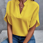 Blouse jaune élégante avec col en V, manches courtes fendues, portée avec un jean bleu. Mode féminine chic et décontractée.