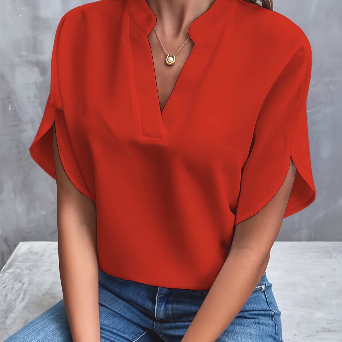 Blouse rouge élégante avec col en V, manches courtes, portée avec un jean bleu. Mode féminine, tenue décontractée chic, style moderne.
