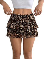 Femme portant une mini-jupe léopard à volants, taille haute, avec un haut blanc. Mode tendance, style animalier, tenue estivale chic.