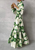 Robe longue à motifs tie-dye vert et blanc, manches bouffantes, ceinture à la taille, femme tenant un livre, style bohème chic.