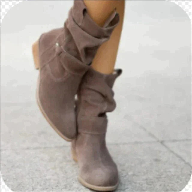 Bottes en daim marron clair pour femme, style décontracté avec talon bas, idéales pour l'automne et l'hiver, sur fond de trottoir gris.