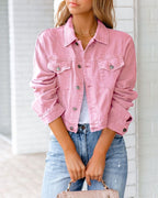 Veste en jean rose pour femme, manches retroussées, portée avec un t-shirt blanc et un jean bleu. Mode décontractée, tendance printemps-été.