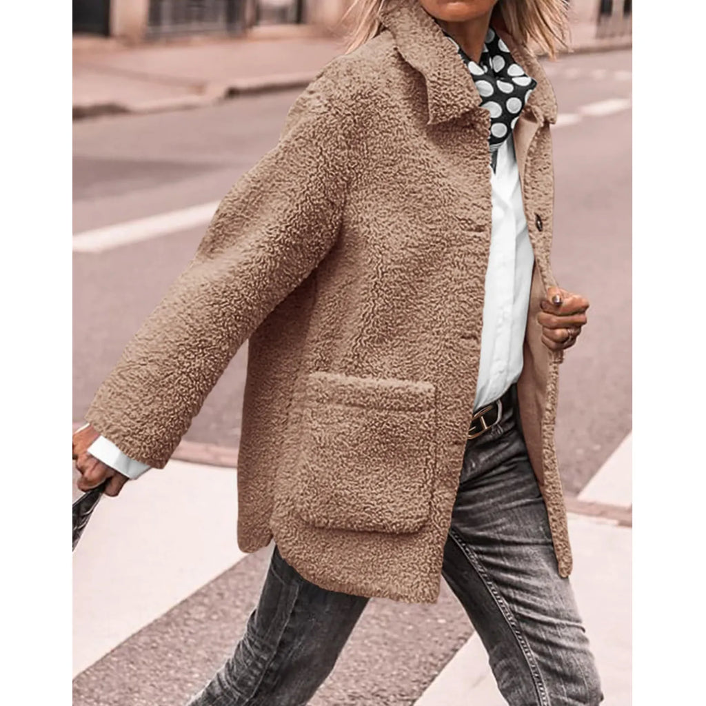 Veste en laine bouclée beige pour femme, style automne-hiver, avec poches avant, portée sur chemise blanche et jean, mode urbaine chic.