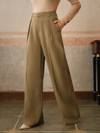 Pantalon large kaki élégant pour femme, style chic et moderne, avec poches, porté dans un intérieur vintage. Mode féminine tendance automne.